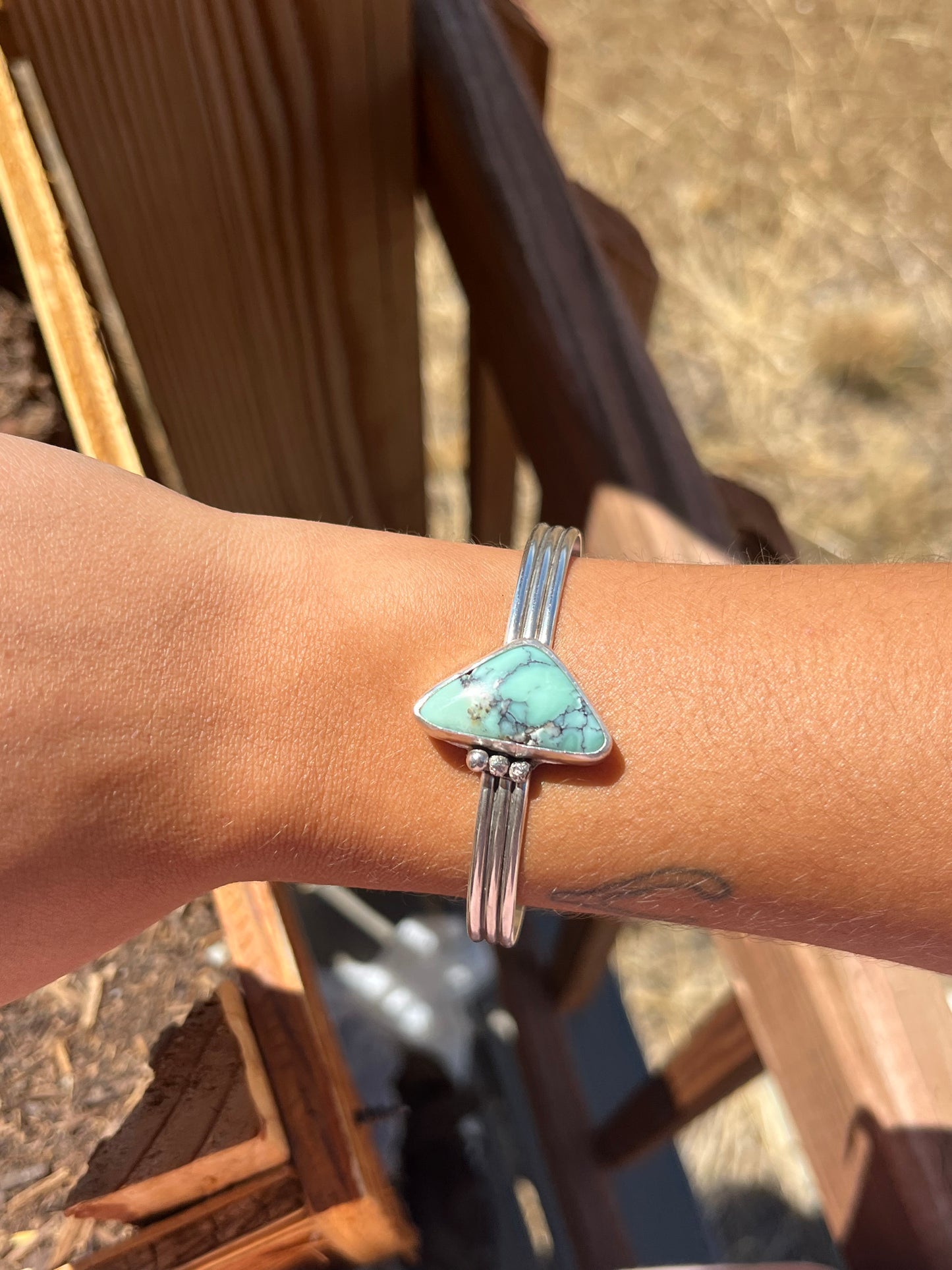 Variscite bracelet on a wrist with a blurred outdoor background